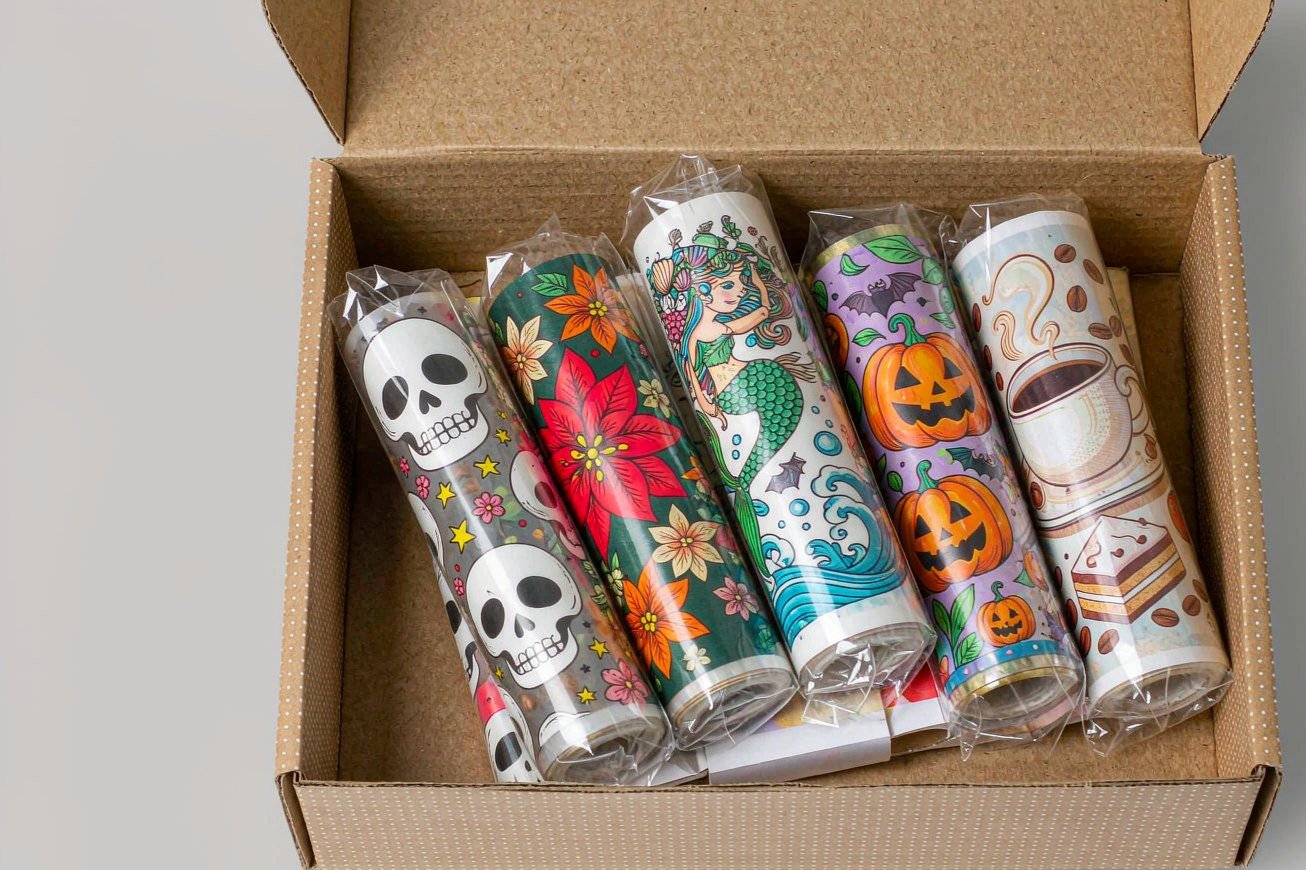 Open kraft sample box with five small printed transfer film rolls